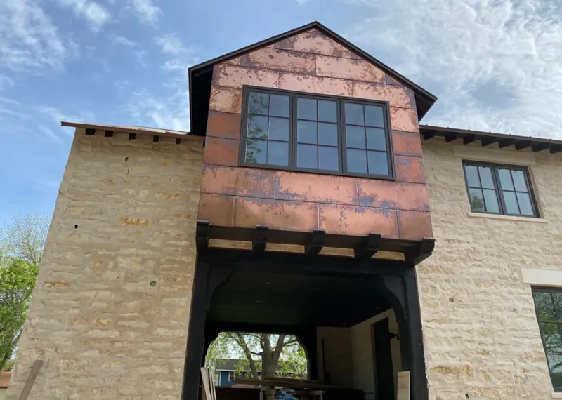 Copper metal panel facade on a stone building for Roof Repair in Coffeyville