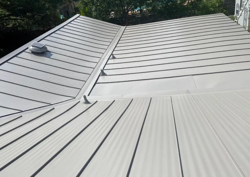 Solar attic fan installed on a metal roof for Roof Ventilation in Coffeyville