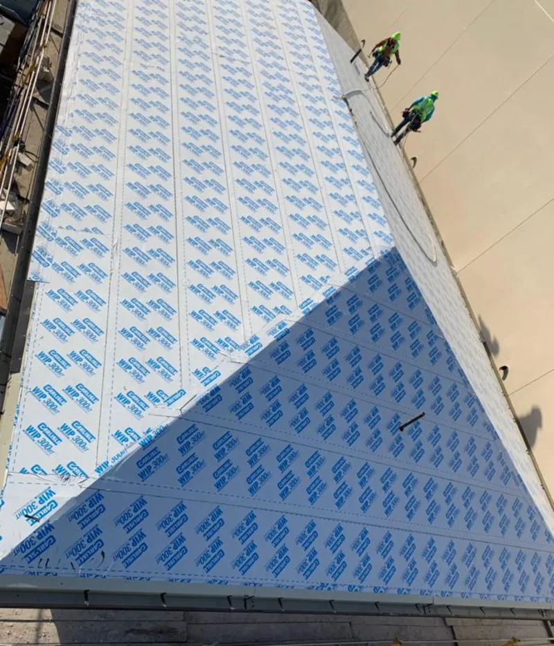 Professional roofers installing underlayment on a metal roof in Coffeyville